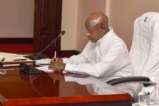 President Museveni signing a document