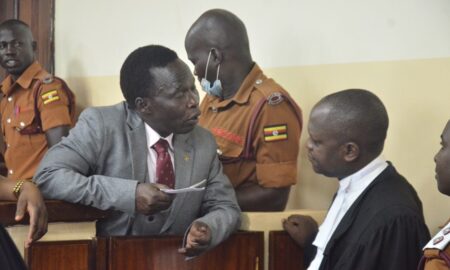 Thomas Kwoyelo ineract with his lawyer Boris Anyuru at ICD sitting at Gulu High Court Circuit on 30t