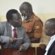 Thomas Kwoyelo ineract with his lawyer Boris Anyuru at ICD sitting at Gulu High Court Circuit on 30t